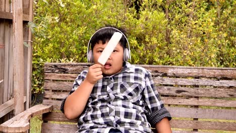 Cute-asian-niños-comen-helado-y-escuchar-música-en-el-Parque