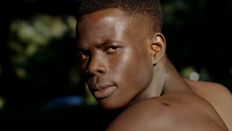 Angry-black-shirtless-african-man-turning-and-staring-at-camera