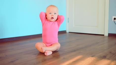 Niedliche-kleine-Mädchen-sitzen-auf-dem-Boden-zu-Hause.-Glückliche-Kindheit