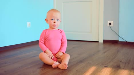 Schöne-Baby-zu-Hause-auf-dem-Boden-sitzend