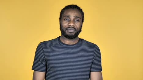 Casual-African-Man-Gesturing-Thumbs-Down-Isolated-on-Yellow-Background