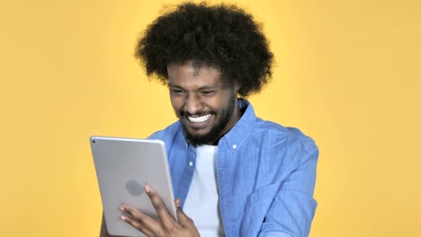 Afro-American-Man-Excited-for-Success-while-Using-Tablet-on-Yellow-Background