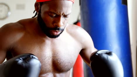 Male-boxer-in-aggressive-mood-in-fitness-studio-4k