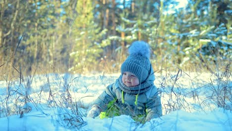 Kind-sitzt-in-den-Schnee.-Baby-ist-umzusehen.-Wintertag