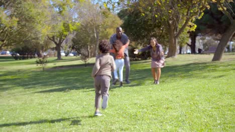 Happy-kids-running-to-Interracial-parents-in-park