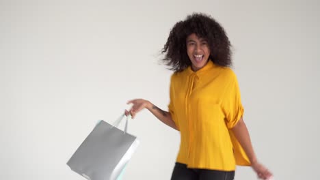 African-american-woman-walking-and-spinning-while-carrying-shopping-bags