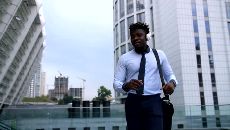 Carefree-black-businessman-dancing-in-city-street