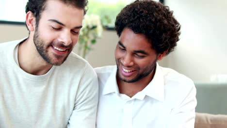 Gay-couple-looking-pictures-together-on-their-camera