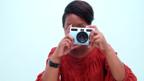 Childish-young-african-woman-taking-a-photo-with-vintage-camera