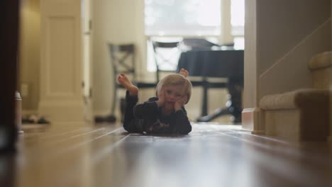 Little-girl-laying-on-her-stomach-at-home-making-goofy-faces