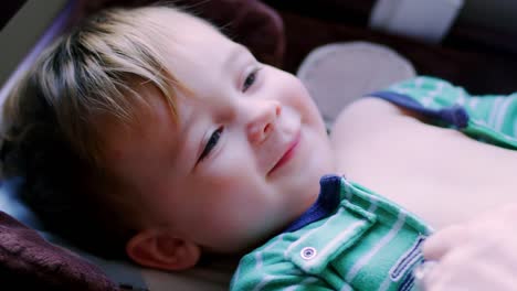 Adorable-baby-boy-in-pajamas-laying-on-a-changing-table,-looking-up