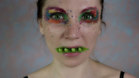 4k-Shot-of-a-Woman-with-Multicoloured-Make-up-with-Beans-in-mouth