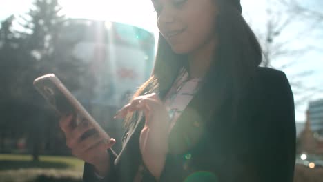 Portrait-of-young-African-American-woman-using-phone,-outdoors.