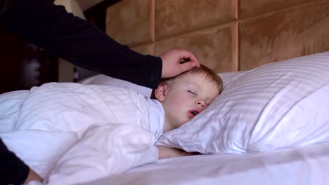 The-little-boy-is-sleeping-in-the-bed.