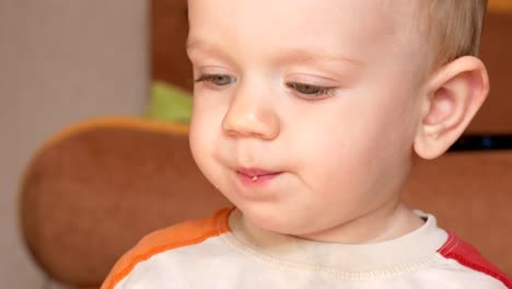 Süßes-Kind-zwei-Jahre-einen-Muffin-zu-Hause-essen.-Close-up