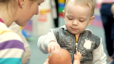 Cute-blond-babe-is-playing-with-toys-in-the-mall.-Children's-area-to-leave-children-when-shopping