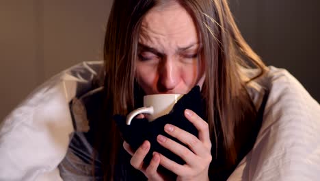 The-ill-woman-drinking-the-hot-drink.-Portrait.-Close-up.-4K.