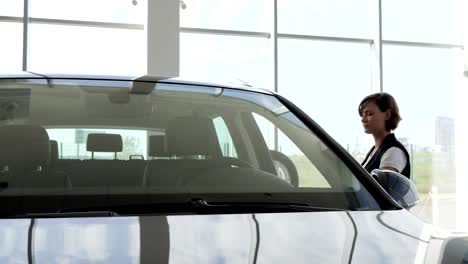 Young-woman-holding-keys-to-new-vehicle,-smiling-at-camera,-joyful