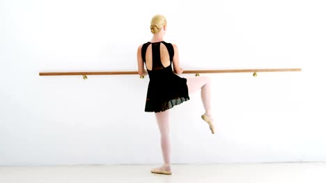 Ballerina-practicing-ballet-dance-at-barre