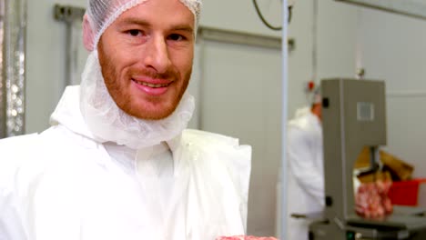 Portrait-of-butcher-holding-red-meat