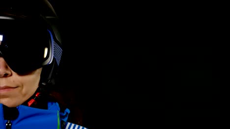 Half-face-portrait-of-skier/snowboarder-woman-with-glasses-on-black-background