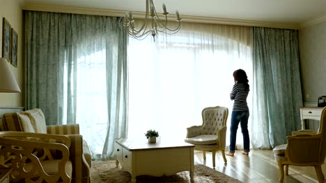 Upset-woman-going-forth-and-back-along-the-window-of-a-cozy-apartment