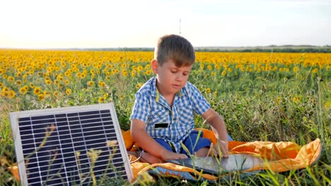 environmentally-friendly,-child-shows-hand-gesture-like-near-solar-photovoltaic-panels-on-background-field,-boy-uses-solar-energy