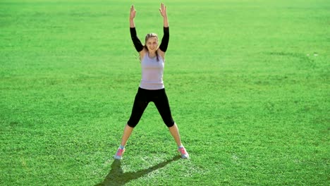 Slim-athletic-woman-doing-exercises-on-green-grass