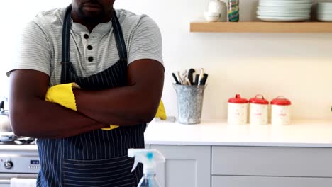 Seguros-de-hombre-de-pie-con-los-brazos-cruzados-en-cocina