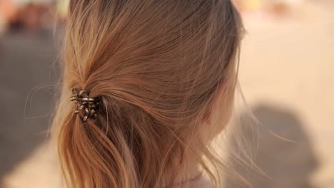 Little-girl-look-at-sea-on-the-beach-in-sunny-weather.-Close-up-portrait