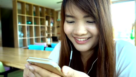 Woman-using-app-on-smartphone-in-cafe-drinking-coffee-smiling-and-texting-on-mobile-phone.-Beautiful-multicultural-young-casual-female-professional-on-mobile-phone.-Mixed-race-Asian-Caucasian-model.