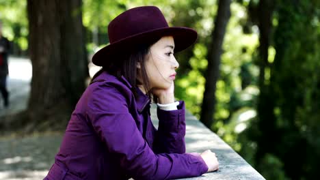 sad,-thoughtful-young-asian-woman-looking-in-camera,outdoor