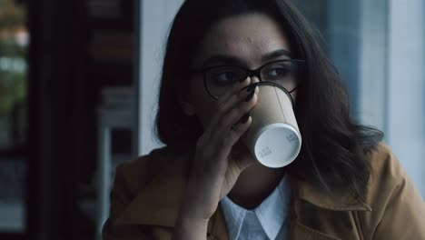 Woman-drinking-coffee-at-the-window