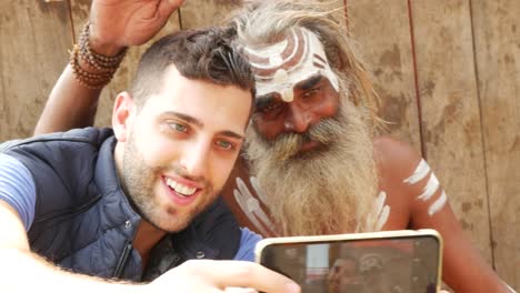 Tourist,-ein-Selbstporträt-mit-Sadhu---heiliger-Mann,-in-Varanasi,-Indien