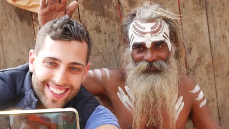 Turista-tomando-una-selfie-con-Sadhu---hombre-santo,-en-Varanasi,-India