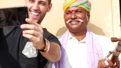 Hombre-tomando-un-selfie-con-un-músico-en-Jaipur,-India