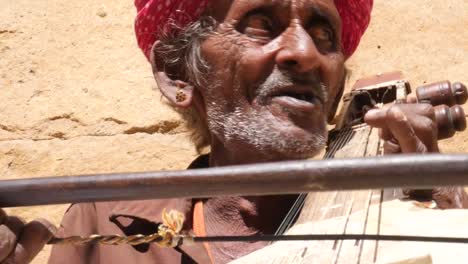 Indische-Senior-spielt-traditionelle-Musikinstrument-in-Jaisalmer-Fort,-Rajasthan,-Indien