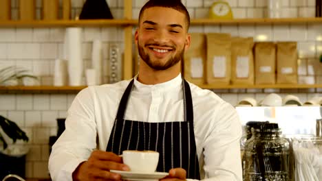 Smiling-waiter-serving-cup-of-coffee-4k