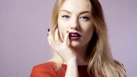 Glückliches-Mädchen-mit-Make-up-und-lila-Lippen-auf-violettem-Hintergrund