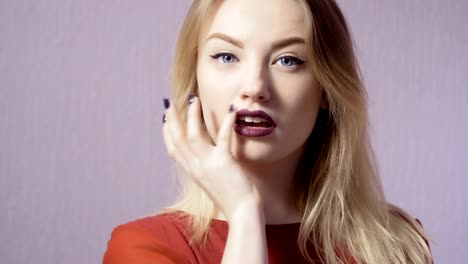 Feliz-chica-con-labios-maquillaje-y-púrpura-en-el-fondo-violeta