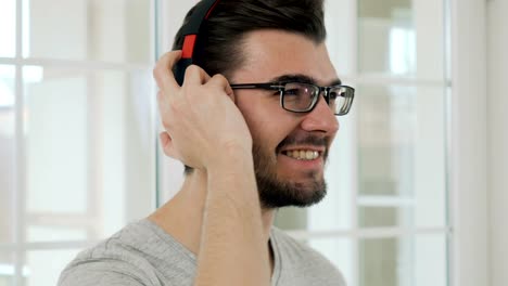 Handsome-guy-in-eyeglasses-listens-music-in-headphones