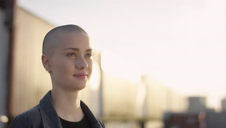 Close-up-of-young-woman-with-buzz-cut-looking-around-in-urban-surrounding