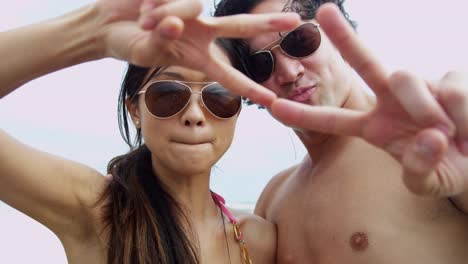 Portrait-Ethnic-couple-filming-beach-vacation-video-selfie