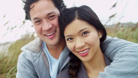 Portrait-Smiling-Young-Asian-Chinese-Couple-Fall-Beach