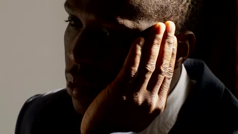 depressed-and-sad-black-business-man-in-the-dark--close-up