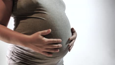 Pregnancy-Concept-Mother-Rubbing-Belly-With-Hands-White-Isolated-Background