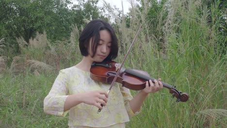 Mujer-asiática-adolescente-tocando-un-violín