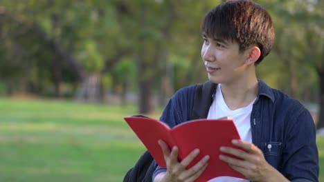 Handsome-student-man-standing-and-hold-red-book-in-hand.-Male-happy-lifestyle.-concept-education.