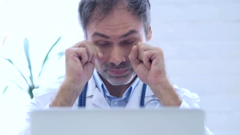 Tired-Doctor-Rubbing-Eyes-while-working-in-Clinic,-Close-Up