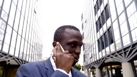 Negro-africano-joven-hombre-en-la-calle-hablando-por-teléfono